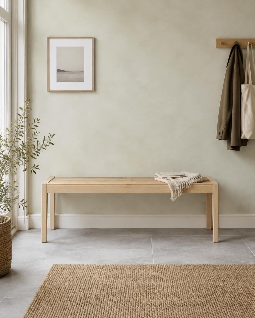 Slatted birch bench in a calm entryway with a coat rail