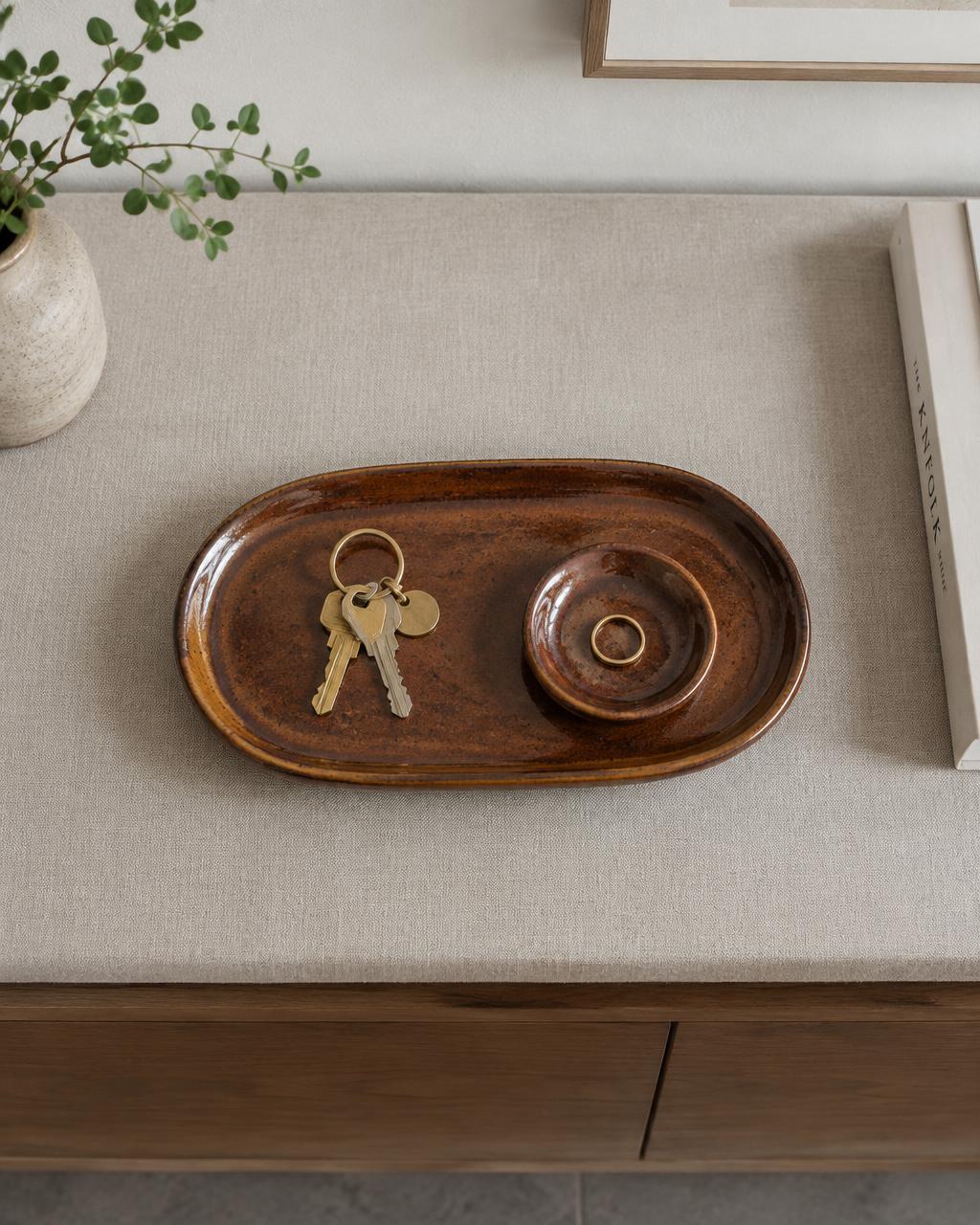 Rust-brown glazed stoneware tray holding keys and a ring dish
