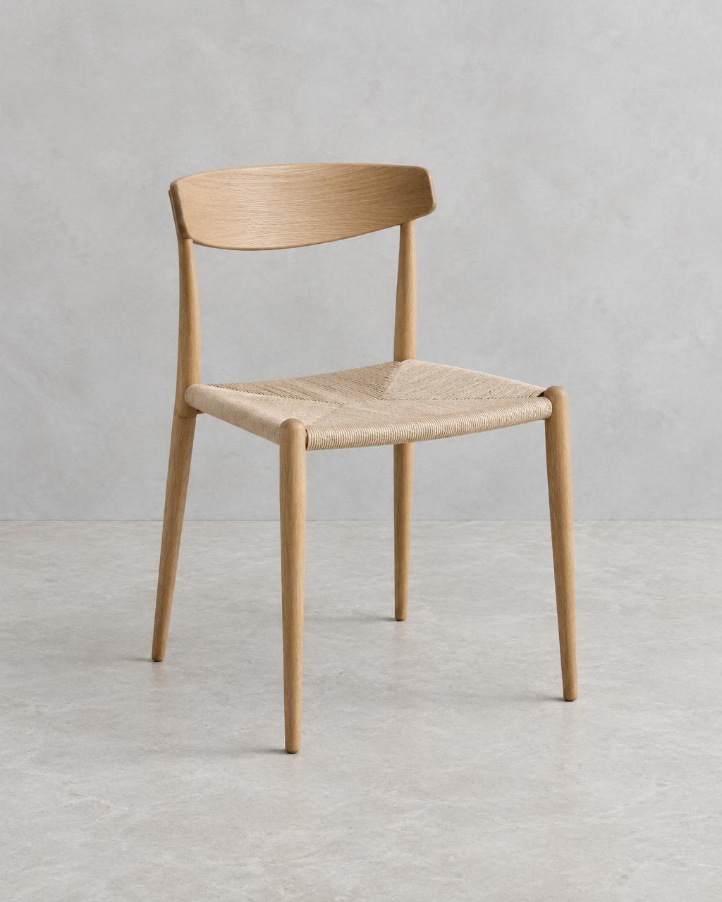Klint light oak dining chair with curved backrest and woven paper-cord seat, shown in full
